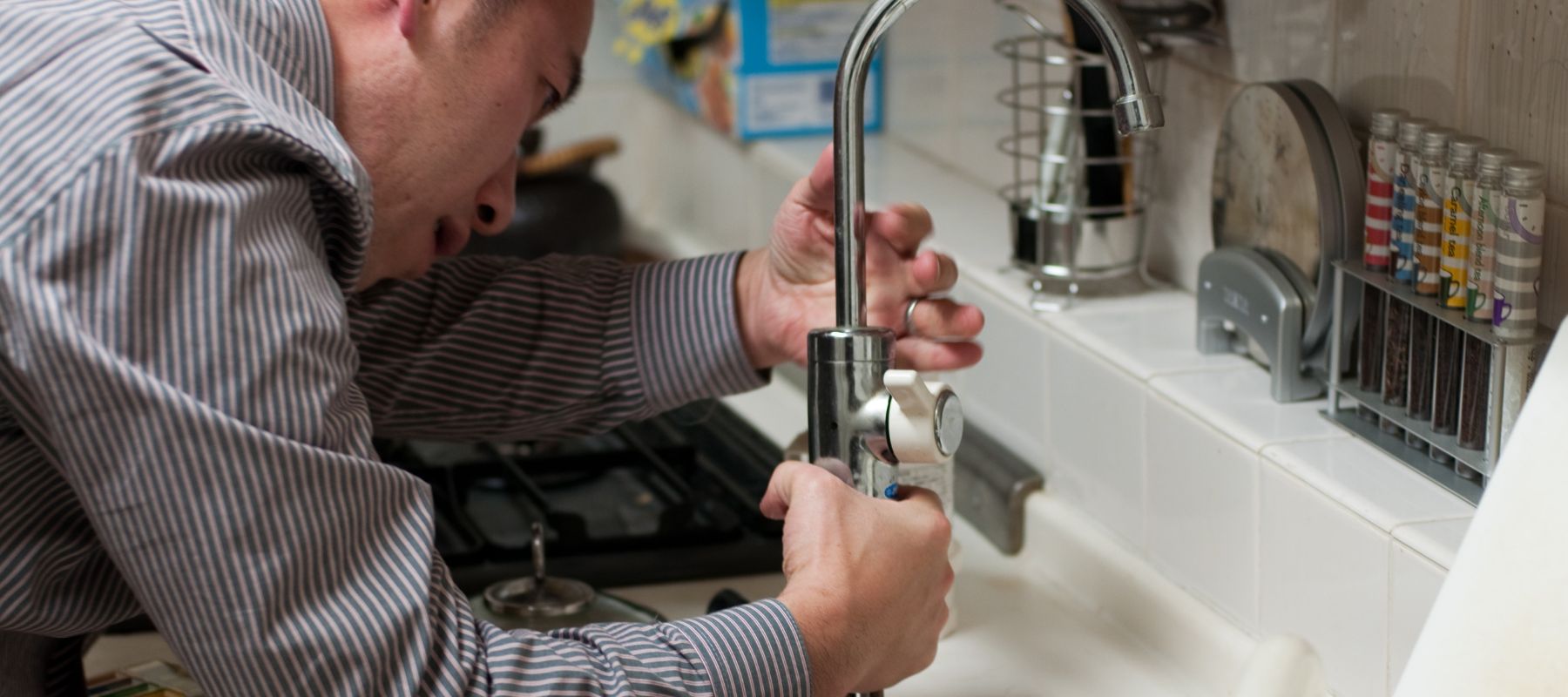 closeup of a plumber from joe cole installing a new sink fixture in a davie florida home