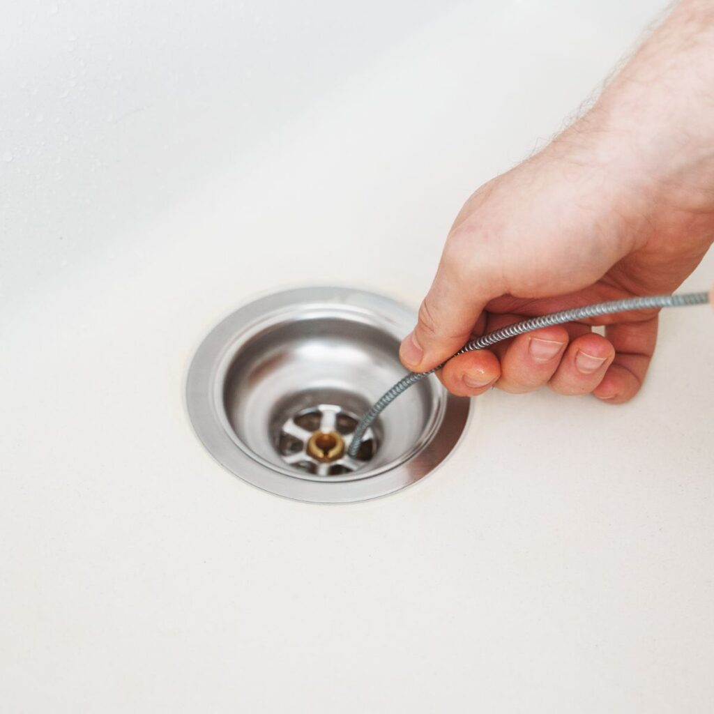 drain snake being used to remove a drain clog