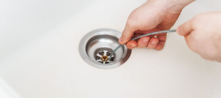 plumber using a drain snake on a drain