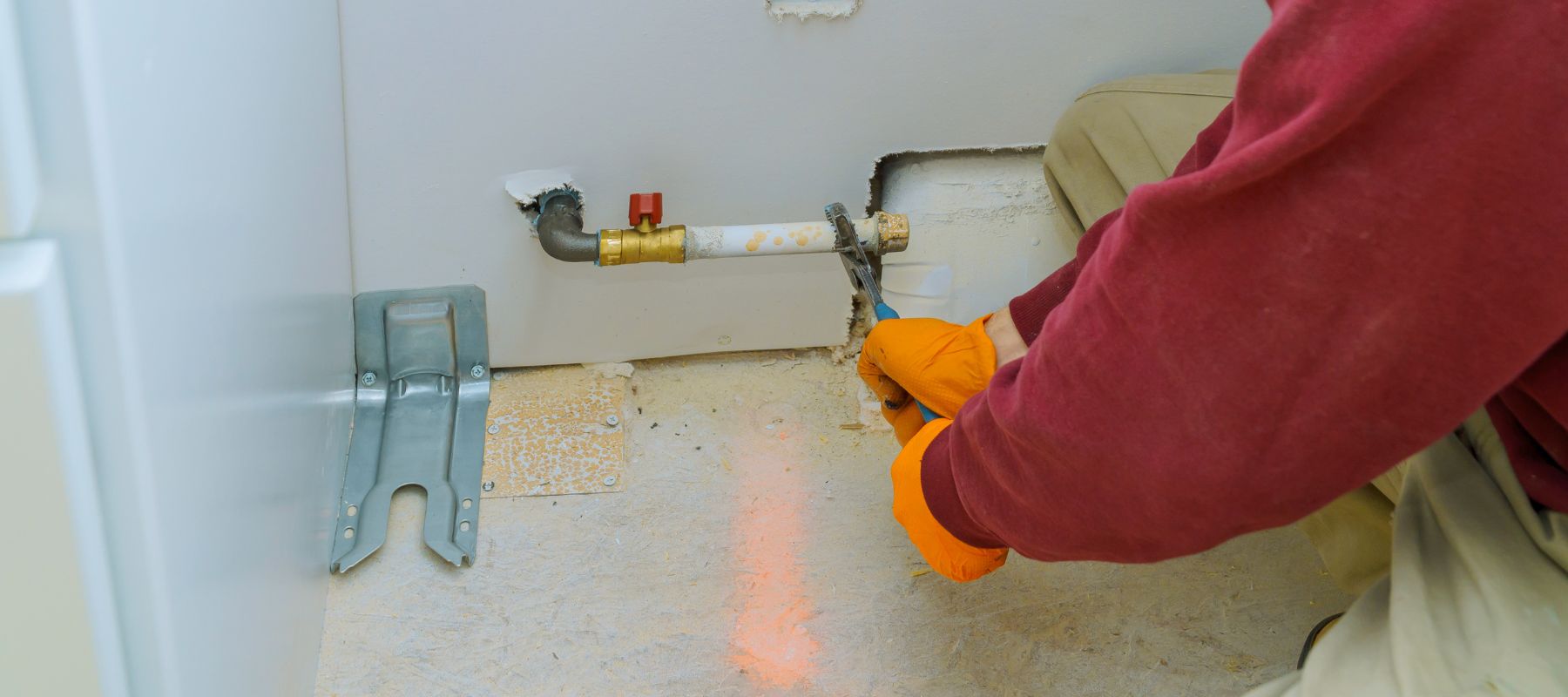gas line plumber using a wrench to tighten a valve