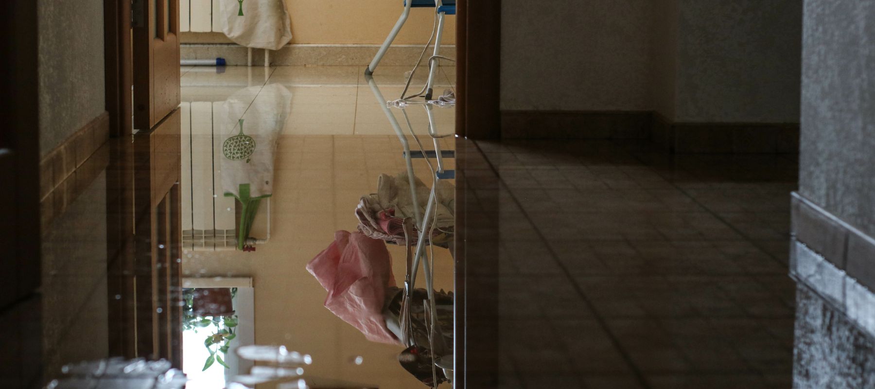 a laundry room flooded with water on floor made made with small squared tiles
