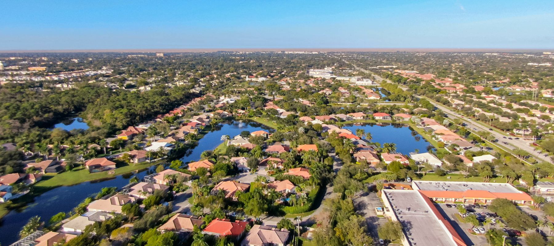 Aerial view of a coastal Florida neighborhood with homes lining the beach and waterway