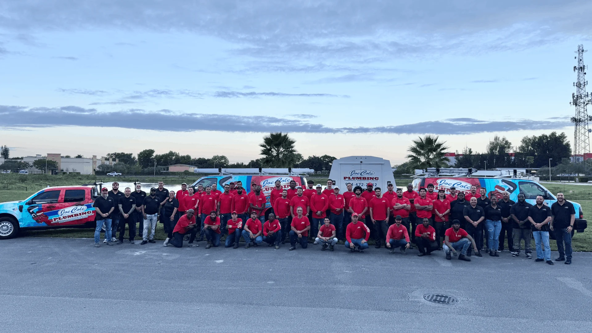 Joe Cole Plumbing team group photo with service trucks
