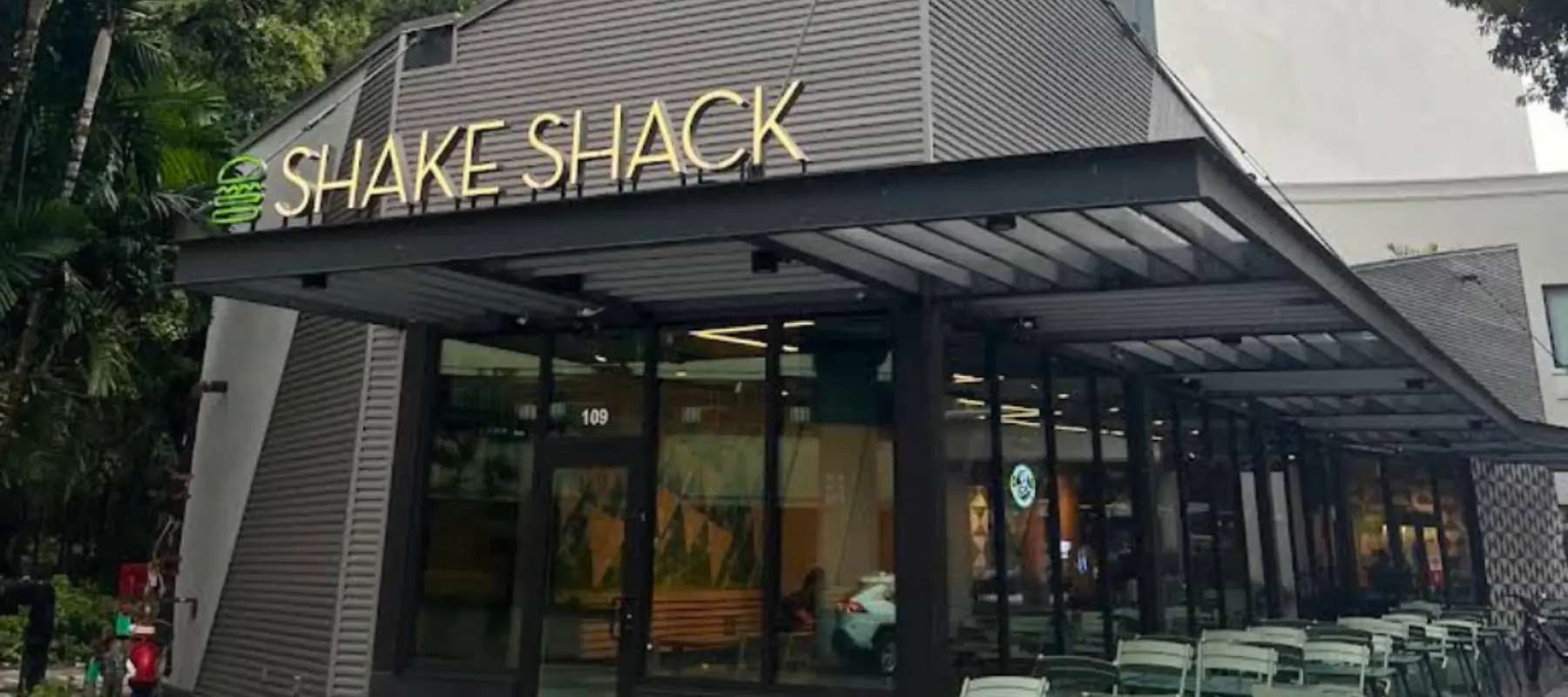 Shake Shack restaurant exterior with modern glass entrance and outdoor seating area